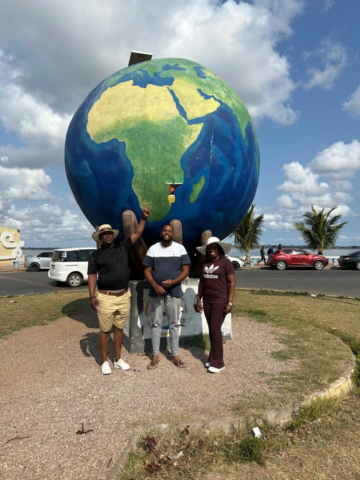 Travellers visiting a large globe landmark together