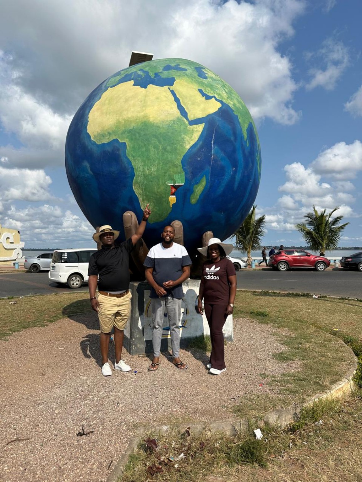 Travellers visiting a large globe landmark together